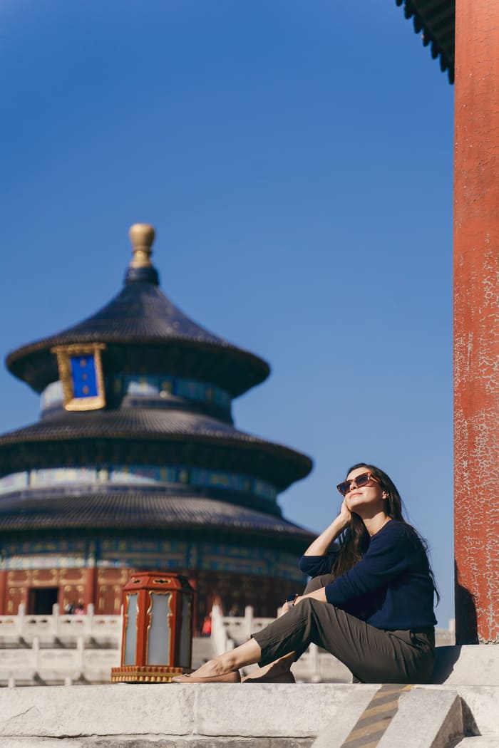 Joven sentada mirando el lugar en beijing